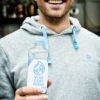 Benjamin Adrion, Vorstand Viva con Agua e.V. und die erste kompostierbare Kunststoffflasche mit Viva con Agua Quellwasser