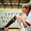 Ein junger Spieler vom FC St. Pauli isst ein Eis und hat einen Eisbeutel auf dem Knie